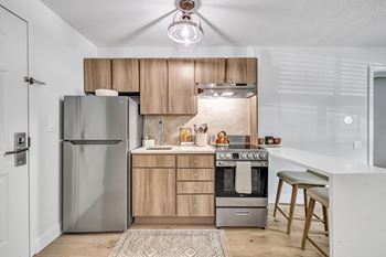 a kitchen with stainless steel appliances and wooden cabinets at The Meriden, Meriden, 06450